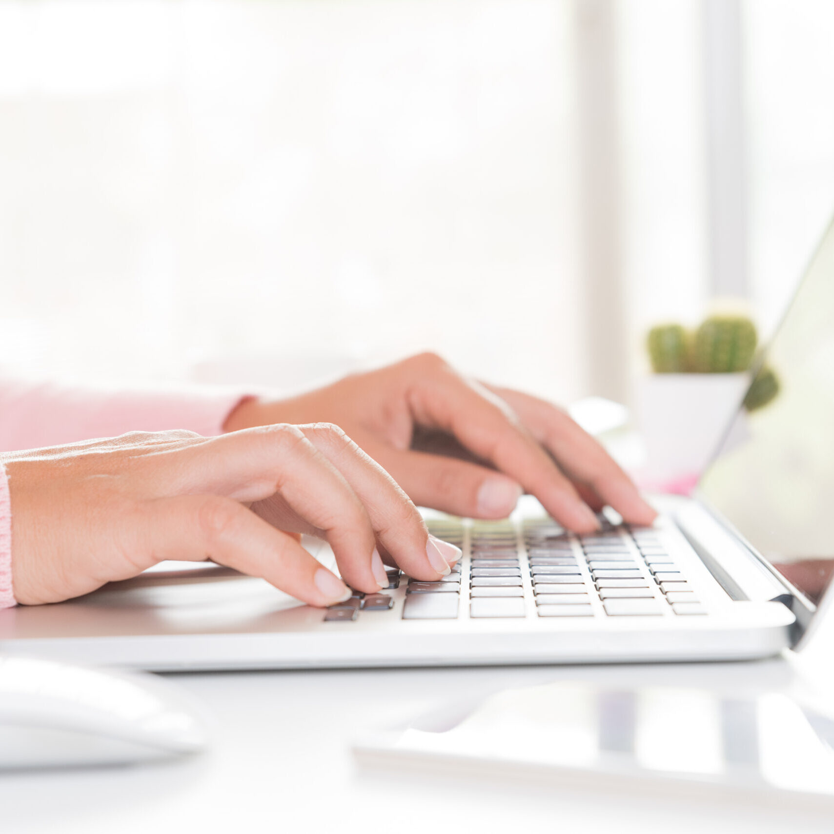 Closeup female hands typing on laptop keyboard. Woman working at home office concept.